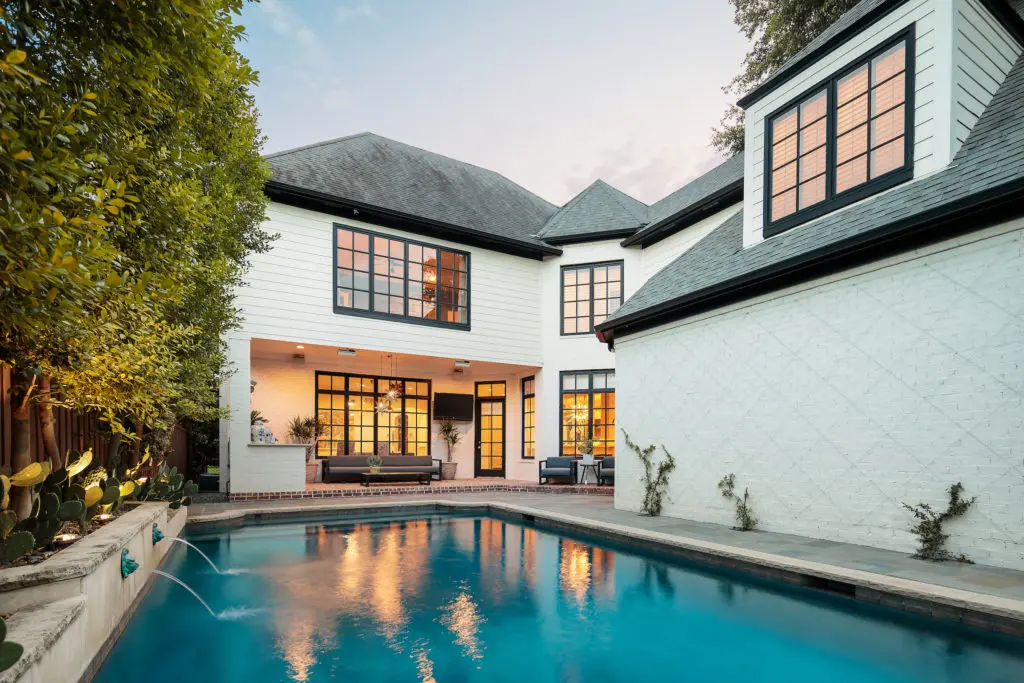 The backyard offers a glistening pool and breezy porch.
