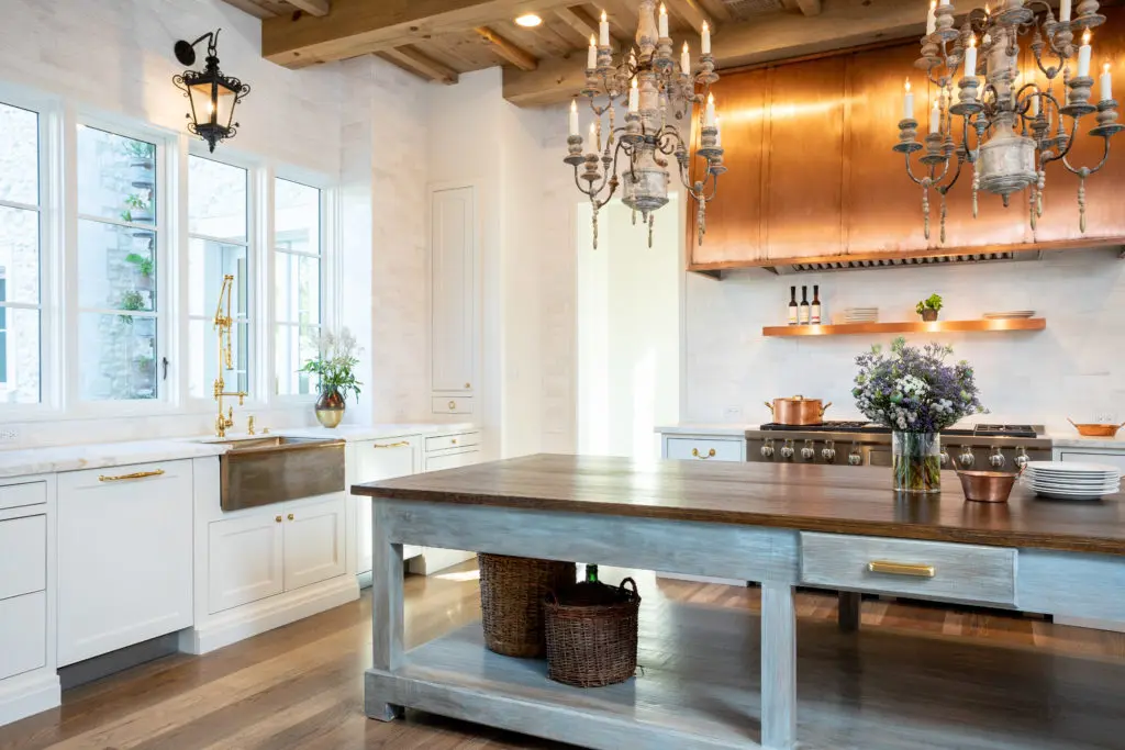 The custom copper oven hood and the handcrafted farm table island are clever design notes. (Photo by Savannah Montgomery)