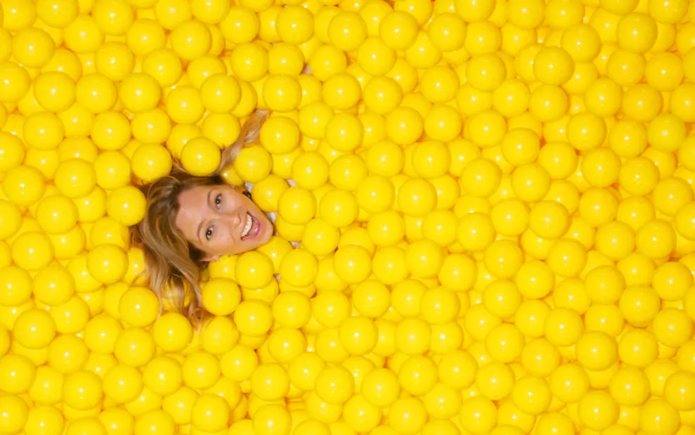 Color Factory CMO Alison Piepmeyer basks in the Yellow Ball Pit, at Color Factory San Francisco, 2017. (Courtesy the artist and Color Factory) 