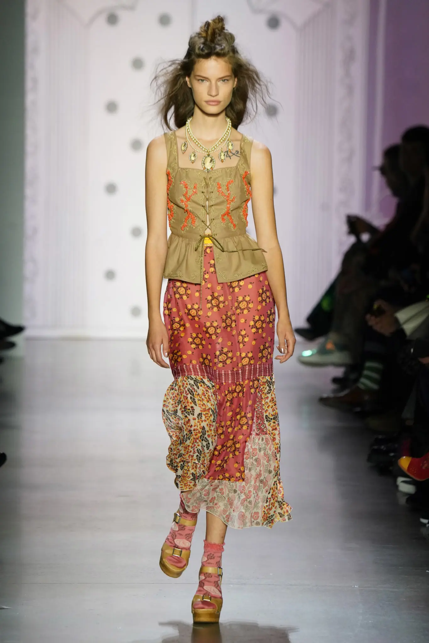Anna Sui coral embroidered khaki twill corset and multi pom pom wisteria border skirt. (Photo by Thomas Lau courtesy of Anna Sui Design Studio)
