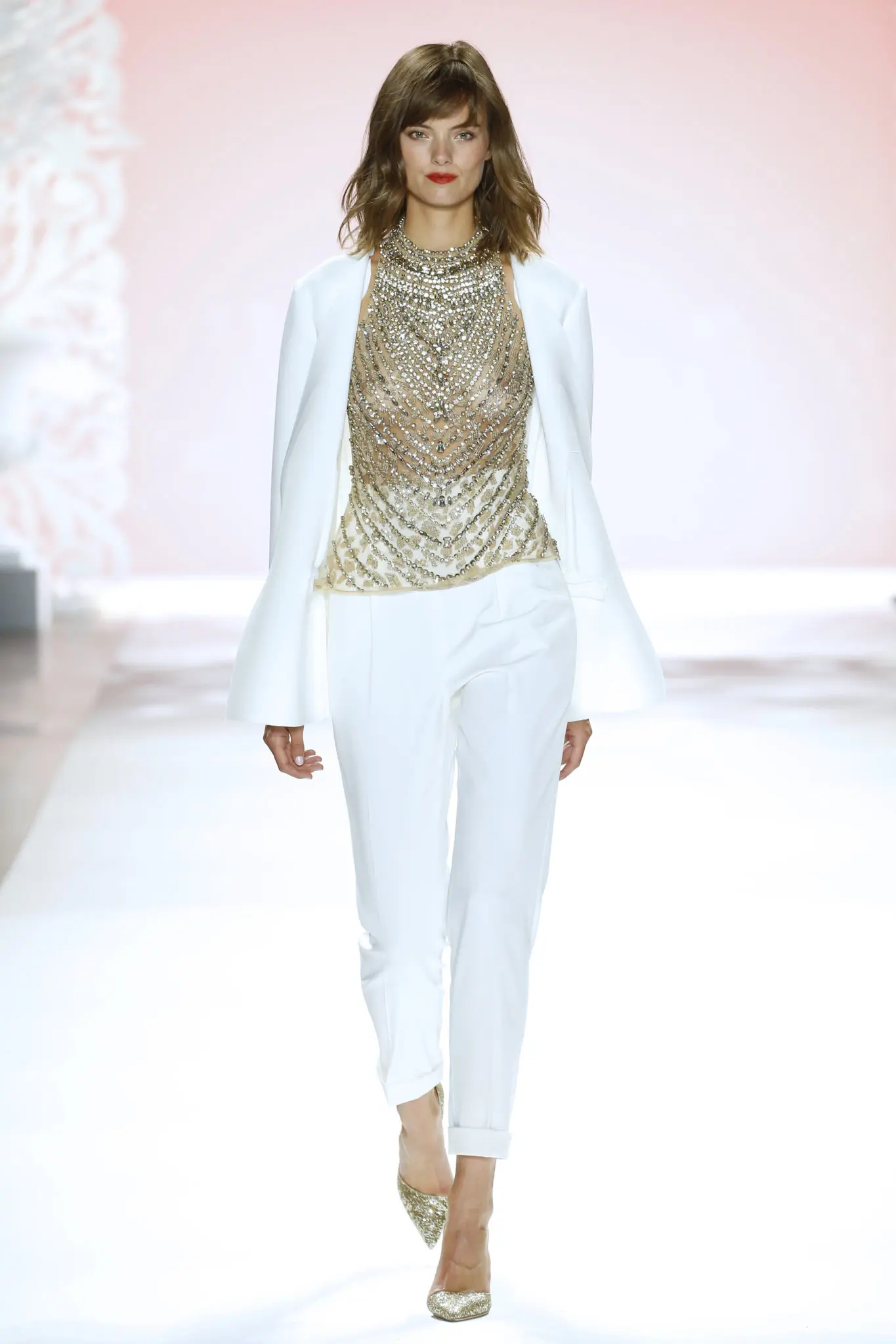 Badgley Mischka white pants suit and gold metallic breastplate blouse. (Photo courtesy of Badgley Mischka)