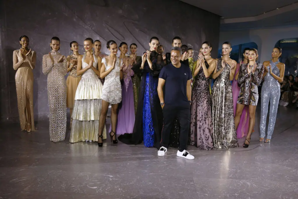 Surrounded by models, Naeem Khan makes a runway appearance at the close of his spring 2020 fashion show. (Photo by Dan Lecca)