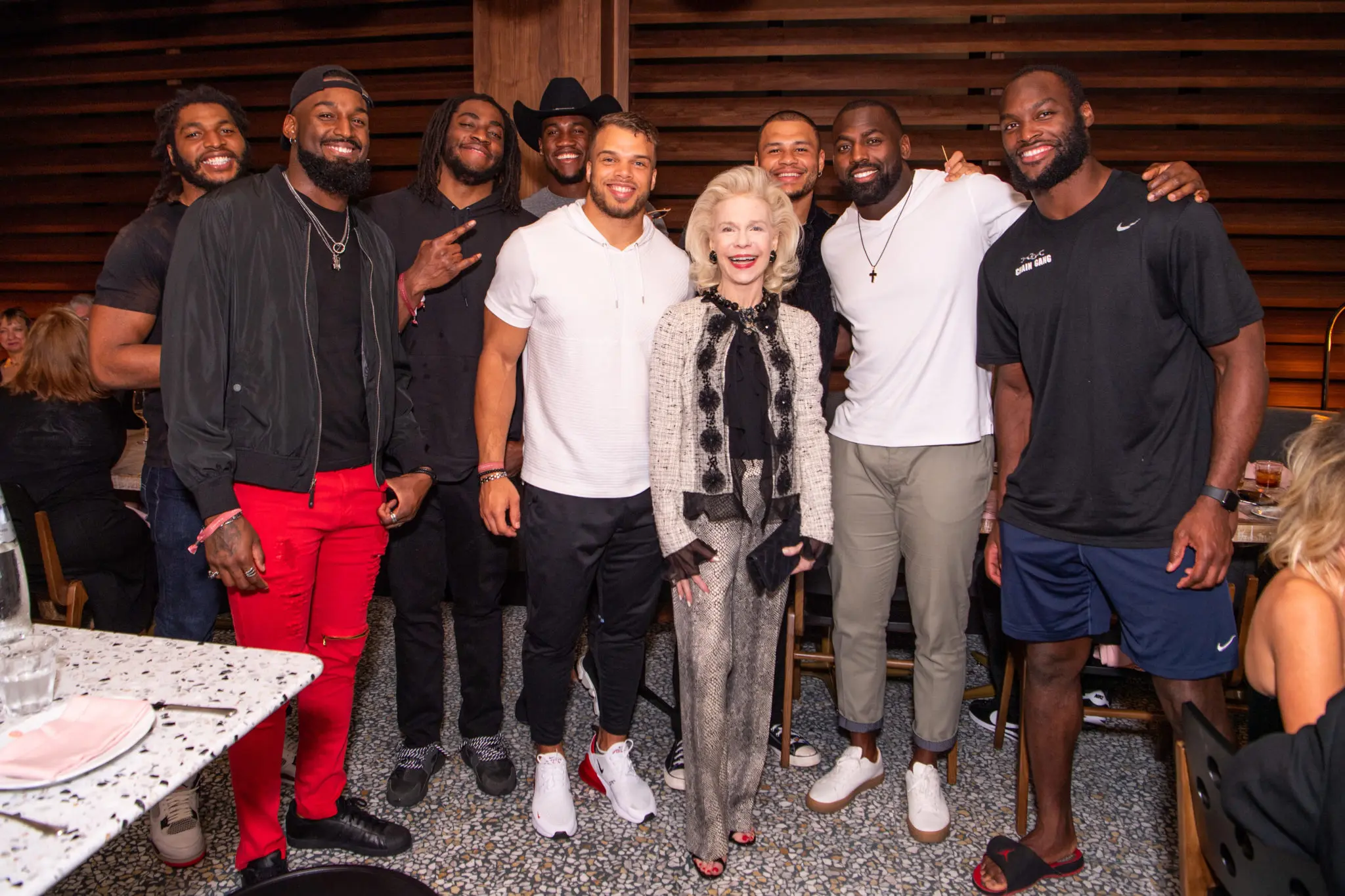 Lynn Wyatt, center, pals around with Houston Texans players Peter Kalambayi. Zach Cunningham, Duke Ejiofor, Jacob Martin, Dylan Cole, Brennan Scarlett, Whitney Mercilus, and Barkevious Mingo at the grand opening of the C. Baldwin Hotel. (Photo by Michelle Watson)