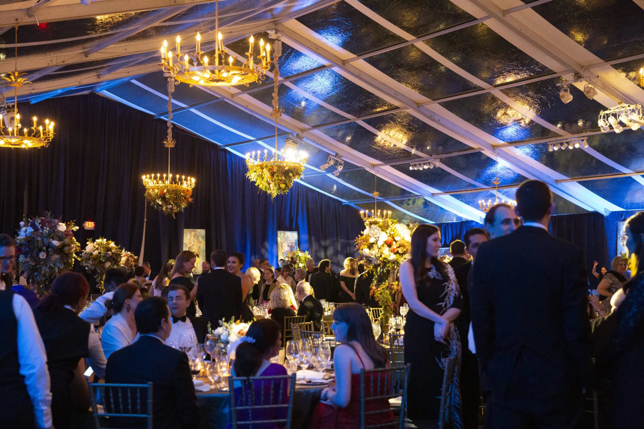 The elaborately decorated party tent on Fish Plaza was illuminated for the opera soirée with chandeliers, some bedecked in flowers. (Photo by Jenny Antill Clifton)
