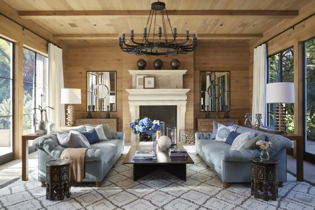 Bullard planked a living room in golden French oak and added huge metal-framed French windows to both ends. The eighteenth-century fireplace is Belgian, and the Berber rug was hand woven for the space. The coffee table is cordovan steel, and the side tables are antiques from India. A Jean Cocteau sketch and Pablo Picasso drawing lean on the mantel. 
