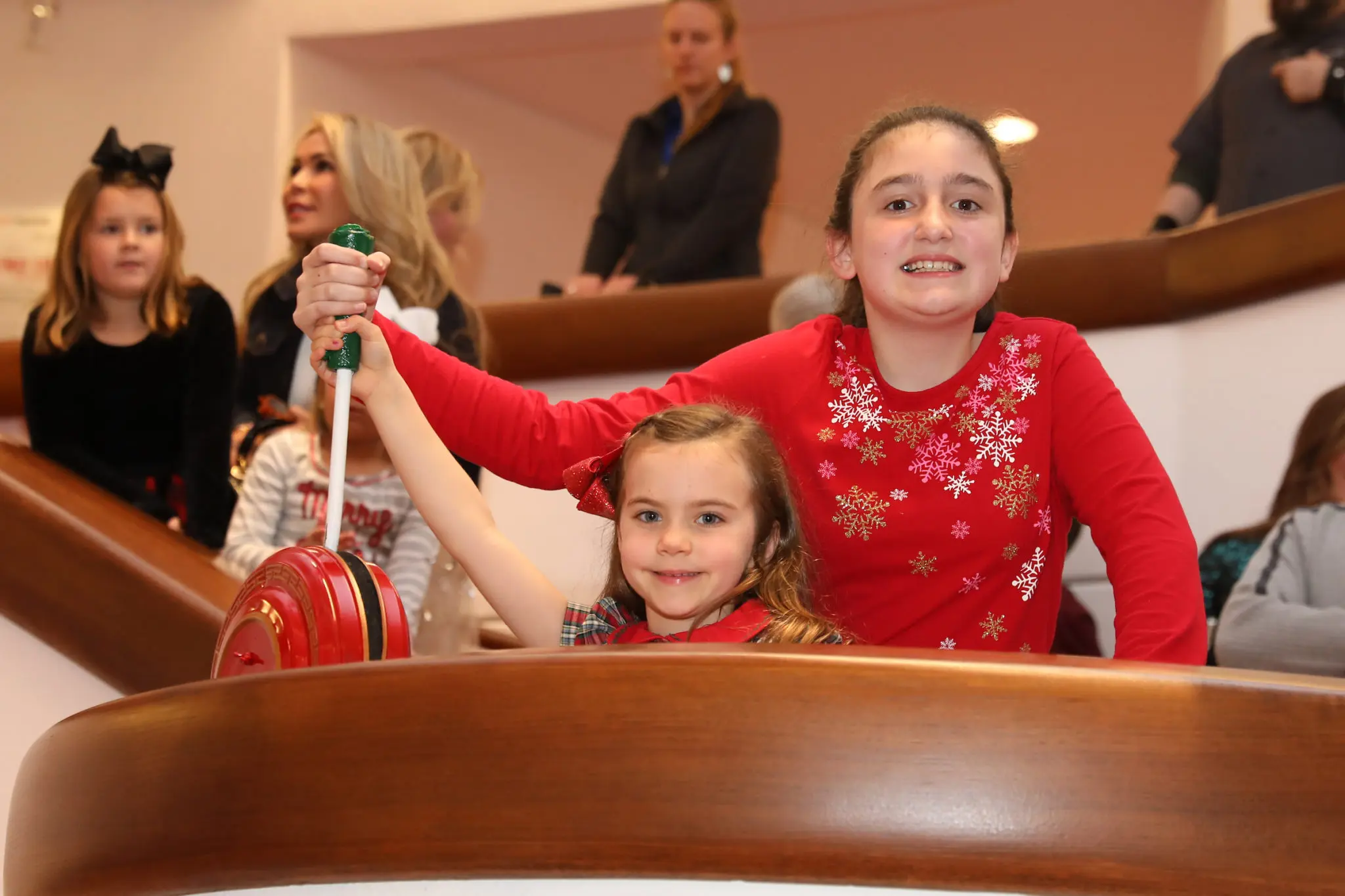 Ava Clark and Claire Garland pull the giant switch that lights the holiday forest. (Photo by Priscilla Dickson)