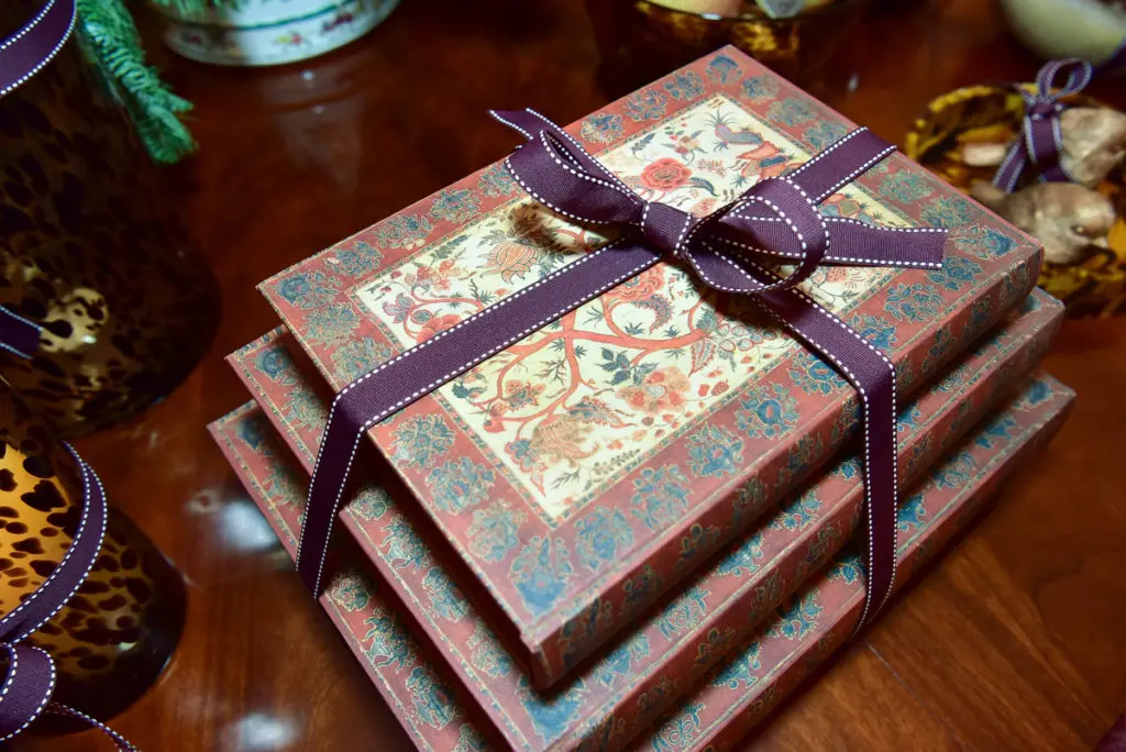 Decorative journals are wrapped in the OKA signature purple ribbon. 