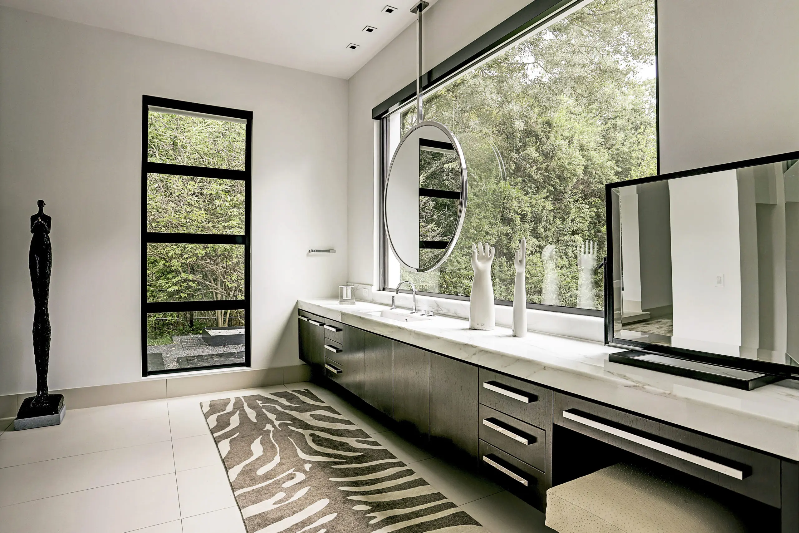 The master bath veatures his and hers Carrera marble vanities, Dorn Bracht faucets, and custom ceiling hanging mirrors. (Photo by TK Images)