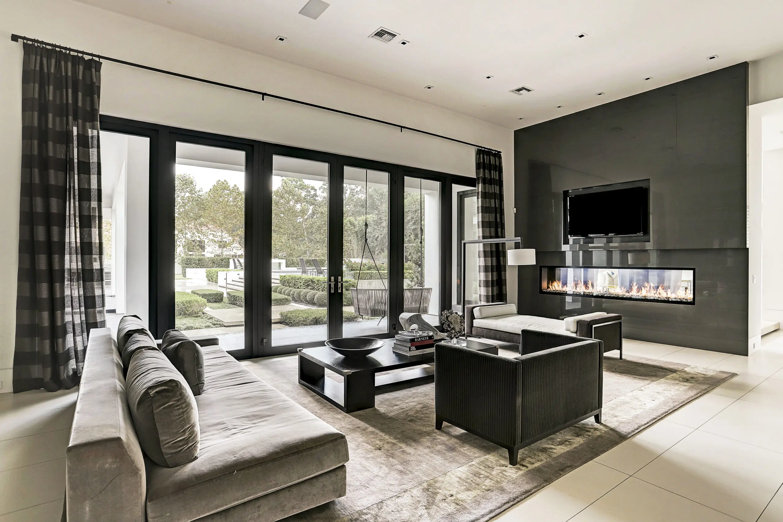 The sophisticated family room boasts a wall of windows and French doors. (Photo by TK Images)