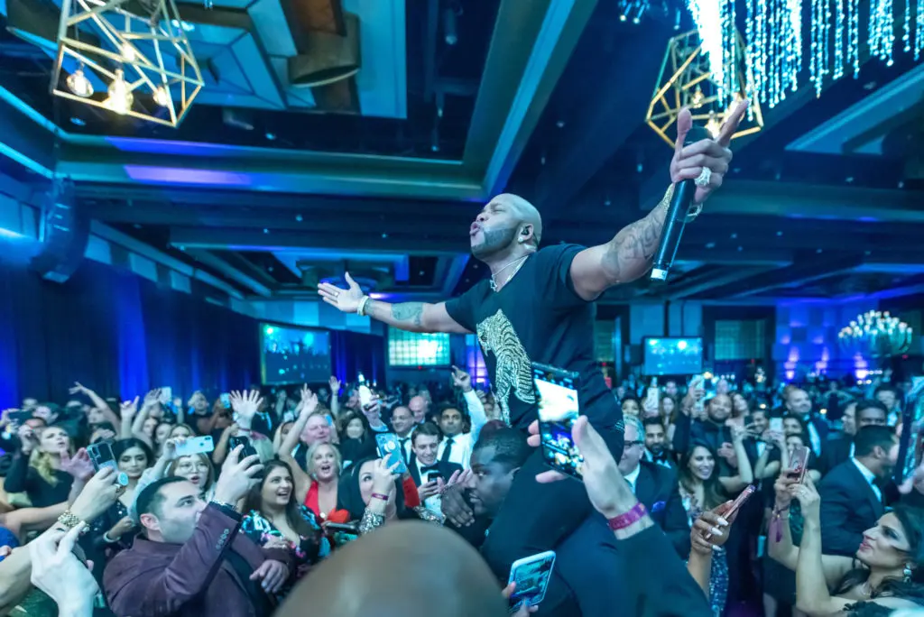Flo Rida celebrates at the Altus Foundation gala, on stage at the Hilton Americas-Houston (Photo by Composure Studio, Versa Creative)