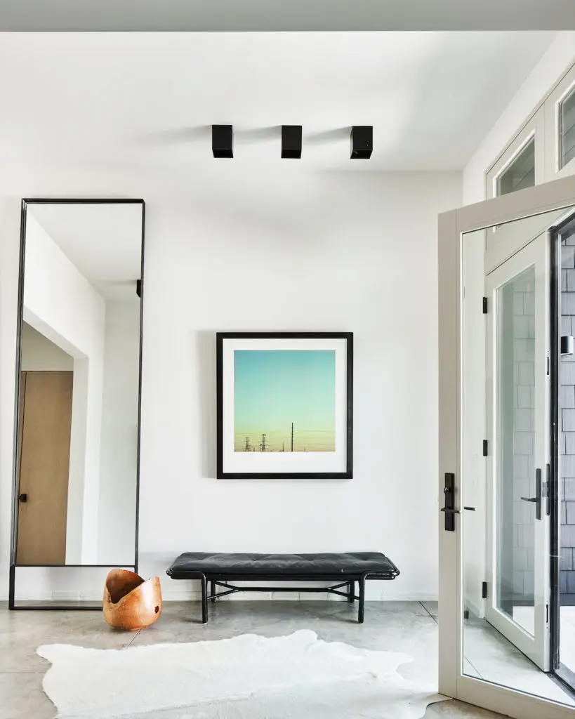 In the entry, raw-steel mirror from Chad Dorsey Design. Vintage McGuire bench. Kyle Warren photograph. (Photo by Stephen Karlisch)