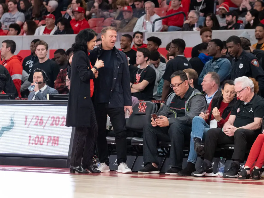 Tilman Fertitta enjoyed a moment with UH president Renu Khator at a UH basketball game. (Photo by F. Carter Smith)
