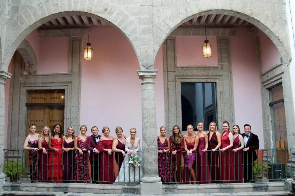 The wedding party and the bride gather for a portrait beneath the arches of the  Colegio de San Ignacio de Loyola Vizcaínas in Mexico City.  (Photo by Graciela Ubando)