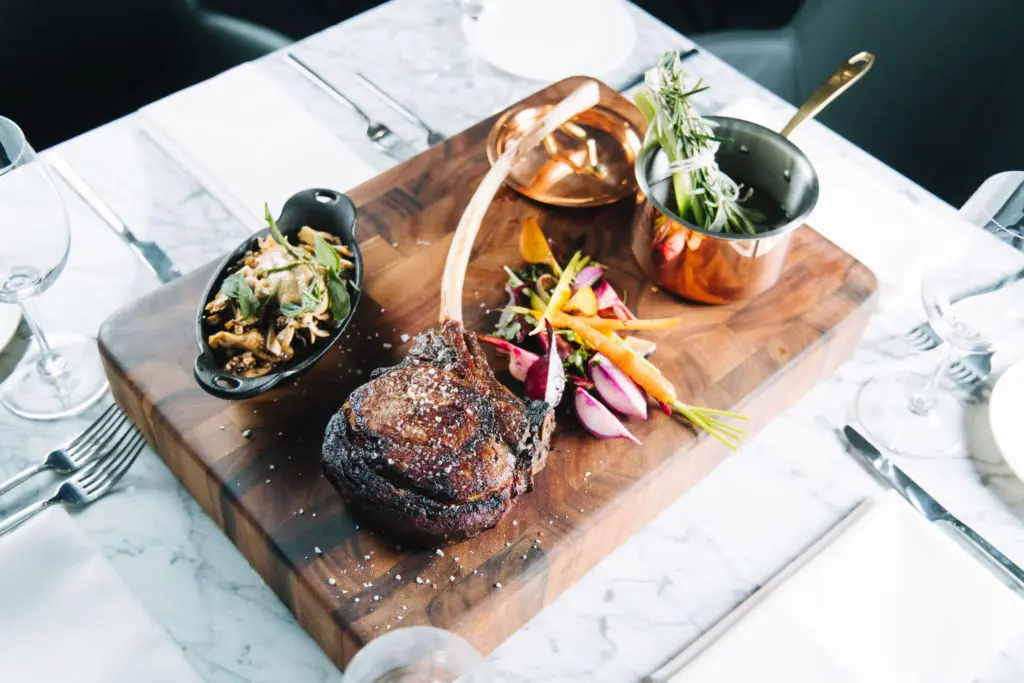 Tomahawk steak with wild mushrooms at Wicked Butcher in Fort Worth's Sinclair hotel. 