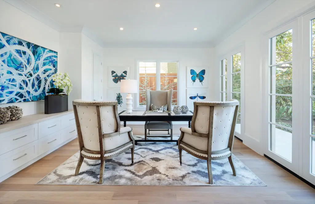 A sunny first-floor office space enjoys a feminine vibe with its blue butterflies and soft coloring. 