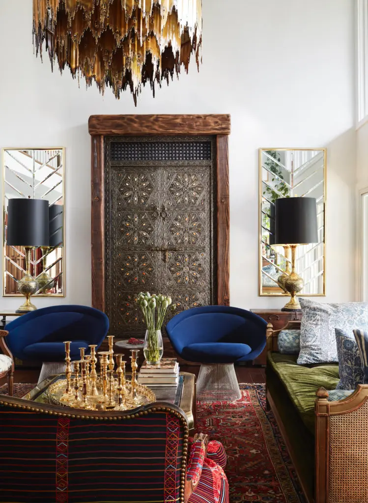 Judy Aldridge is a master of mixing
periods and styles. In the living room,
a pair of blue Warren Platner chairs,
which she bought 30 years ago, with
a late 1950s Tom Greene Brutalist
chandelier, and an antique door and
rug bought in Morocco. (Photo by Lisa Petrole)