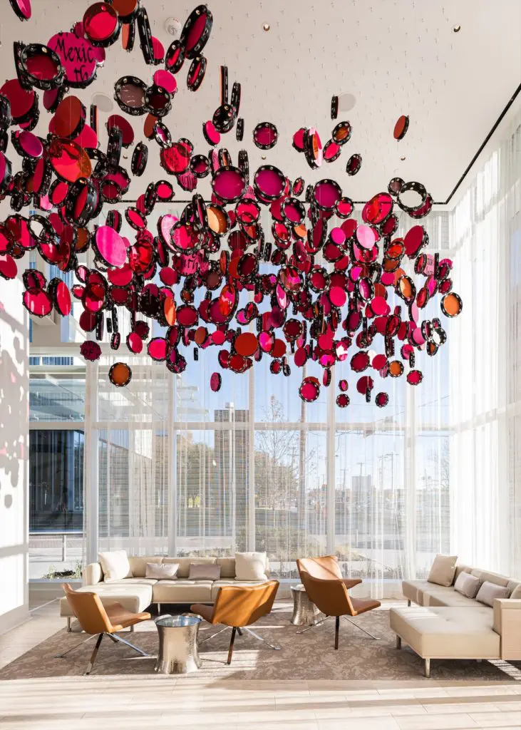 The components of Lava Thomas' "Resistance Reverb: Movements 1," 2018, floating above a lobby seating area in the Hall Arts Hotel, are reminiscent of the tambourines held by activists during the pivotal women’s marches of 2017. (Photo by Robert Tsai)