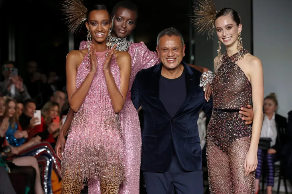 Naeem Khan celebrates with models at the end of his runway show. (Photo by Dan and Corina Lecca)

