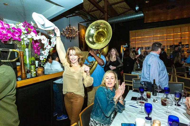 Many among the 300-plus guests join the second line in dancing around the restaurant, napkins twirling overhead. (Photo by Tony Ruppe)