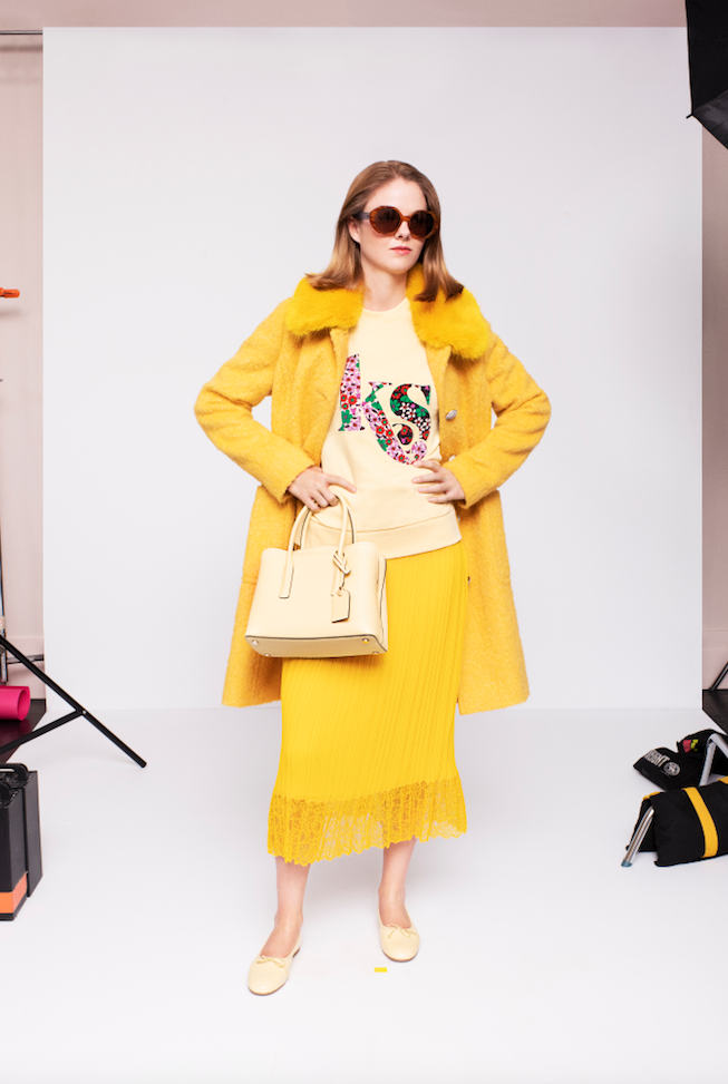 Kate Spade yellow fringe trimmed skirt, KS sweatshirt, yellow coat, beige handbag and shoes. (Photo by Andres Burgos )