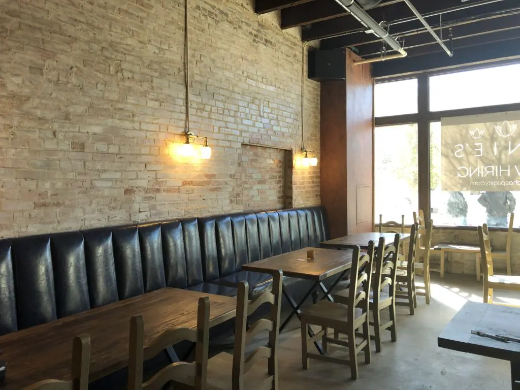 Blue banquette seating flanks the right-hand wall at Tinie's. (Photo by Courtney Dabney.)