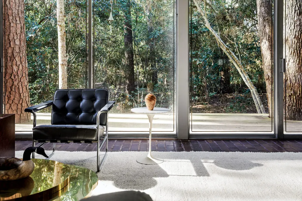 Early-morning light streams through a bank of continuous windows facing a wooded ravine, its moniker: the Tree House.  Eichenberger chair, owned by Sally Walsh, gifted to the Brochsteins. Saarinen table from Evans-Walsh was a wedding present from Raymond’s brother, Branard Brochstein. (Photo by Pär Bengtsson)