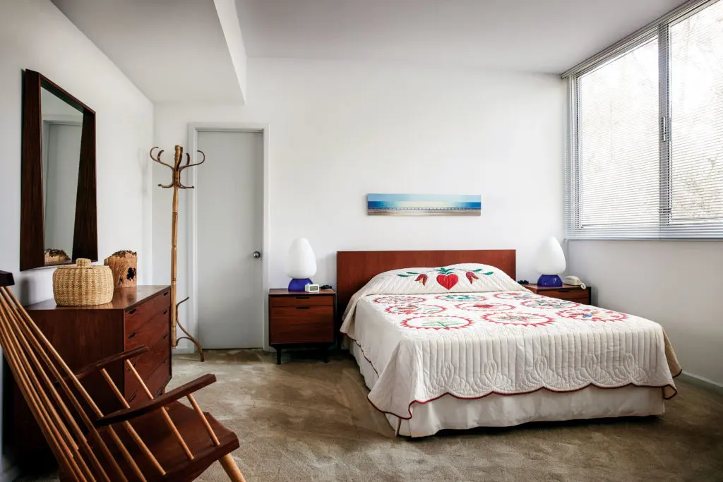 The guest bedroom offers a salute to traditional and modern craft, from the antique American quilt to Thos. Moser New Gloucester rocker. Woody Gwyn landscape. (Photo by Pär Bengtsson)