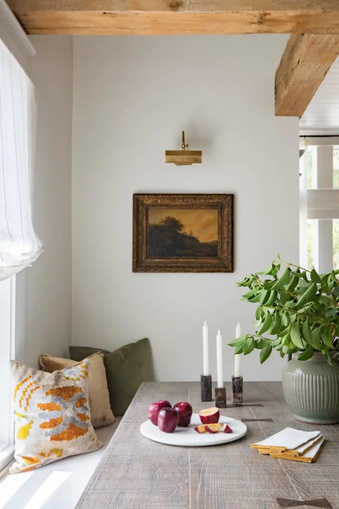 Changing out artwork can make a room feel entirely different, as is the case in the dining nook of Marie Flanigan's modern farmhouse-style guest house dining nook. (Photo courtesy Marie Flanigan Interiors)