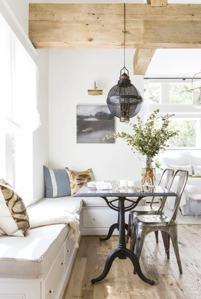 Changing out artwork can make a room feel entirely different, as is the case in the dining nook of Marie Flanigan's modern farmhouse-style guest house dining nook. (Photo by Julie Soefer)