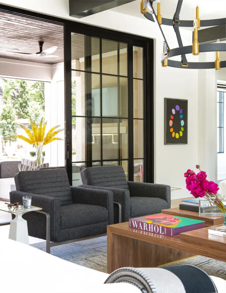 The living room's custom walnut coffee table is designed to pull apart as needed for more intimate gatherings. Lee Jofa chairs, Ralph Lauren light fixture. (Photo by Costa Christ Media)