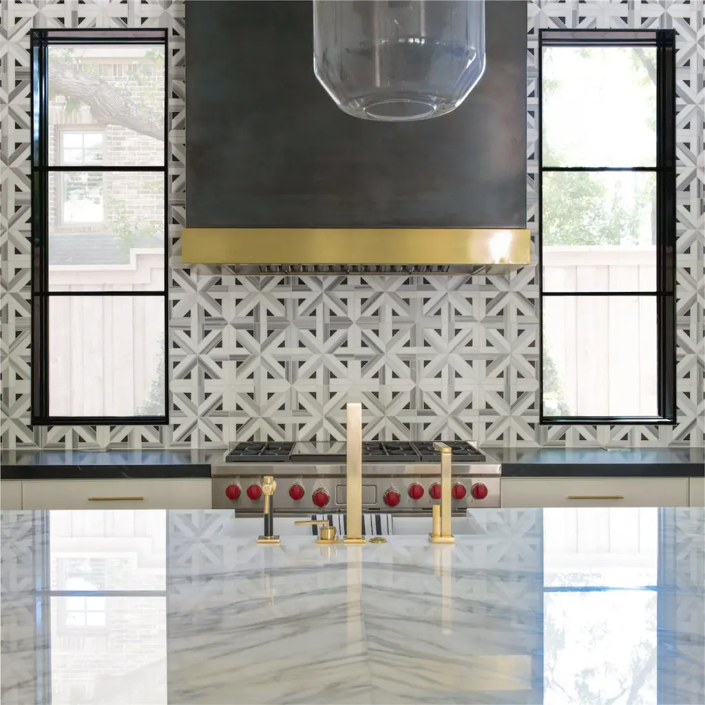 The brass-and-darkened-metal ventilated hood was made by Faulkner Perrin. Westside Kitchen and Bath brass faucet and fittings, Holland Marble countertop, Ann Sacks tile. (Photo by Costa Christ Media)