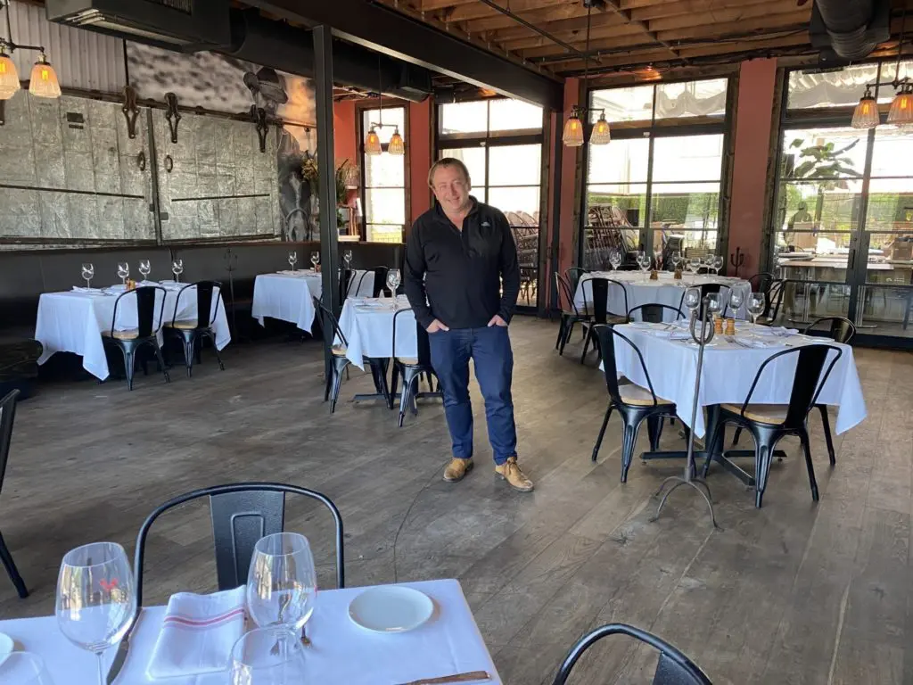 Benjamin Berg in the upstairs dining room at B&B Butchers where tables have been spread out for 25 percent occupancy, but no opening until May 18 when 50 percent occupancy could be possible. (Photo by Shelby Hodge