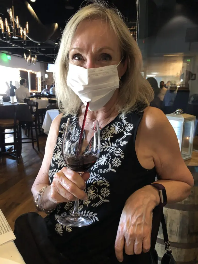 Among diners at Federal American Grill on Friday night, Peggy Tuck crafted her own party mask with a hole for a straw. (Photo by Judy Nichols)