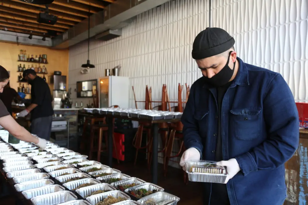 Chef Erik Bruner-Yang helps pack meals at Cane, the first restaurant to reopen under the Power of 10 Initiative, for hospital workers at Medstar Washington Hospital Center.