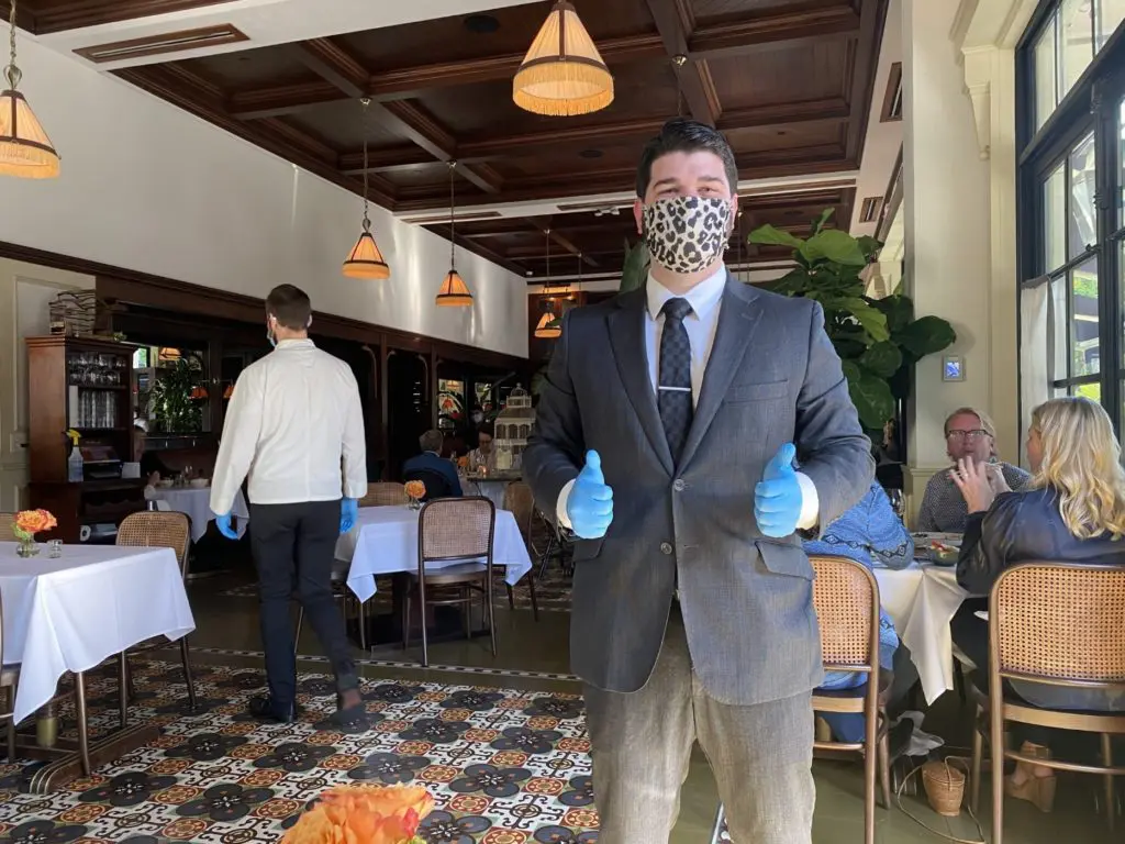Le Colonial GM and sommelier Trevor Wiedeman wears gloves and a mask as do all of his employees during the time of the coronavirus. (Photo by Shelby Hodge)