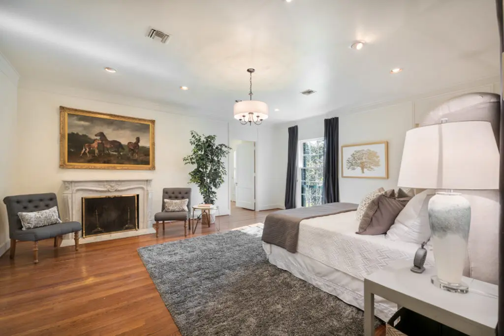 Master Bedroom features marble fireplace, hardwood flooring, elevator and leads to Master Closet with Dressing Room. (Photo by Vlady Ambia)
