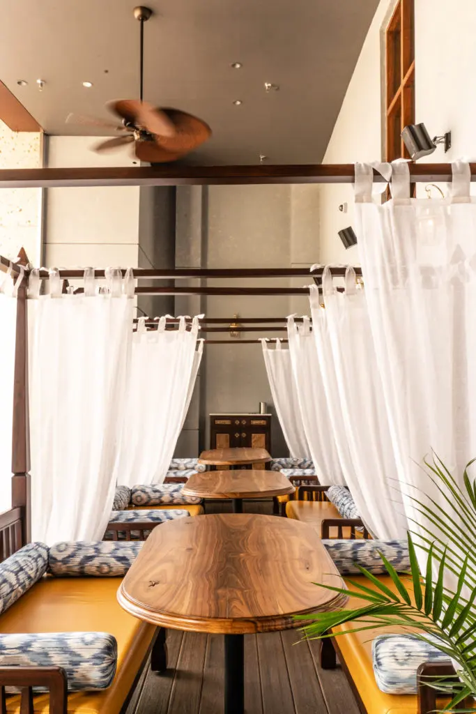 The outdoor lounge at Musaafer is complimented by daybeds draped colonial style in linen and featuring plump bolsters. (Photo by Michael Anthony)