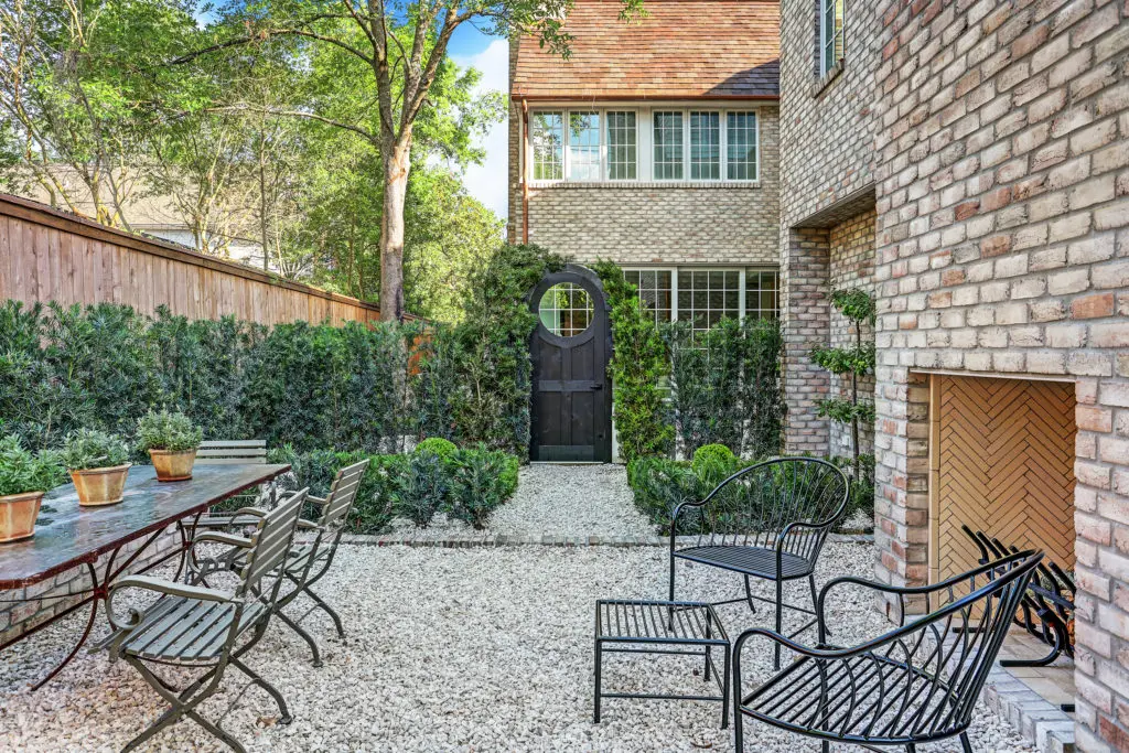 The outdoor entertaining area includes a fireplace and ample seating.