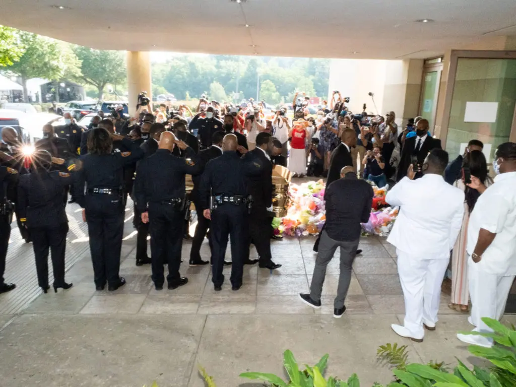 Houston Police officers salute the George Floyd's casket and his family  as they arrive for his funeral at the Fountain of Praise church. (Photo by F. Carter Smith)
