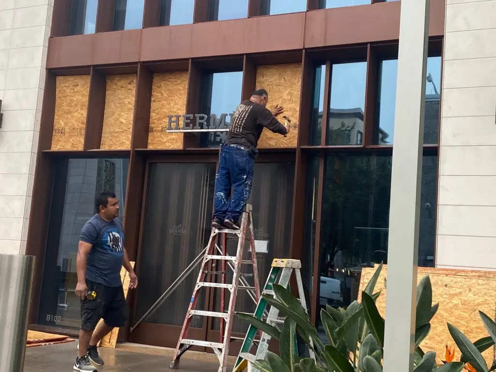The Hermés crew at work boarding up windows and doors at the River Oaks District boutique. (Photo by Shelby Hodge)