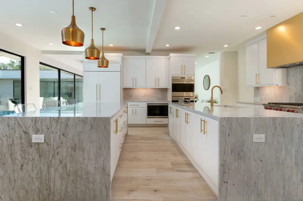 Waterfalls of Carrera marble and brass fittings in the kitchen.