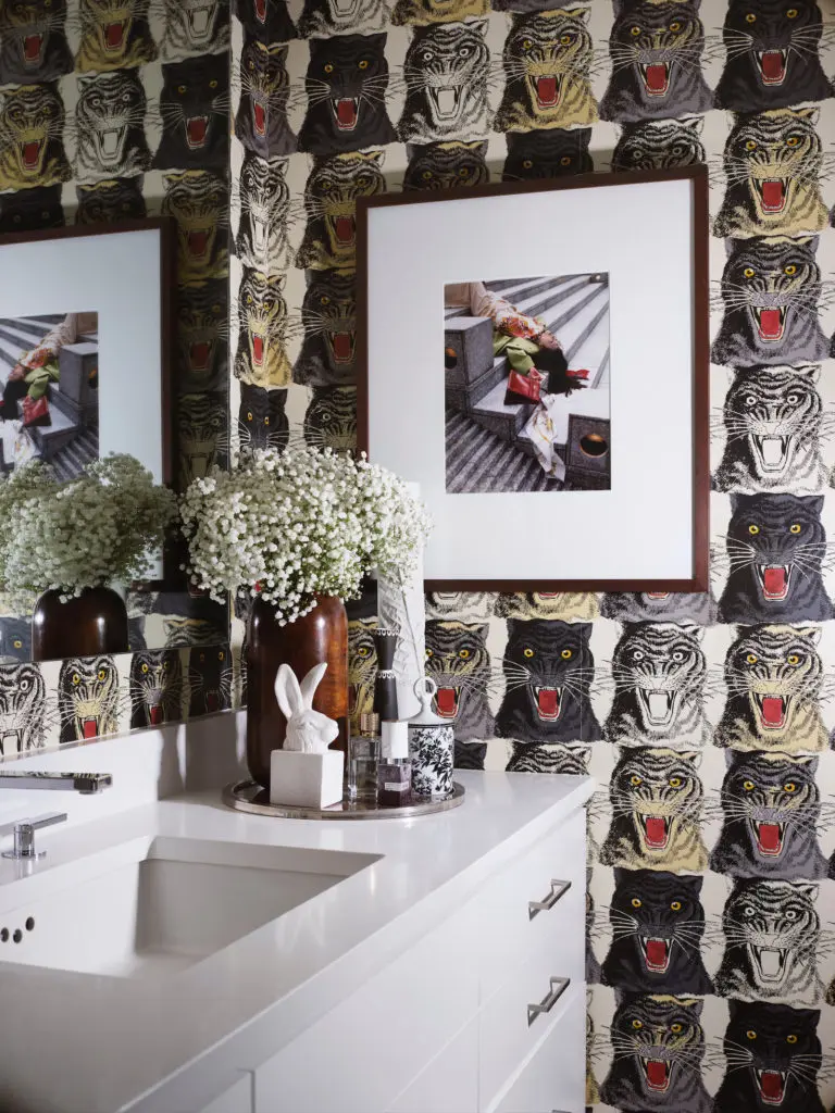 Gucci wallpaper adorns one wall in the bath room. The plaster rabbit sculpture is by George Sellers. (Photo by Lisa Petrole)
