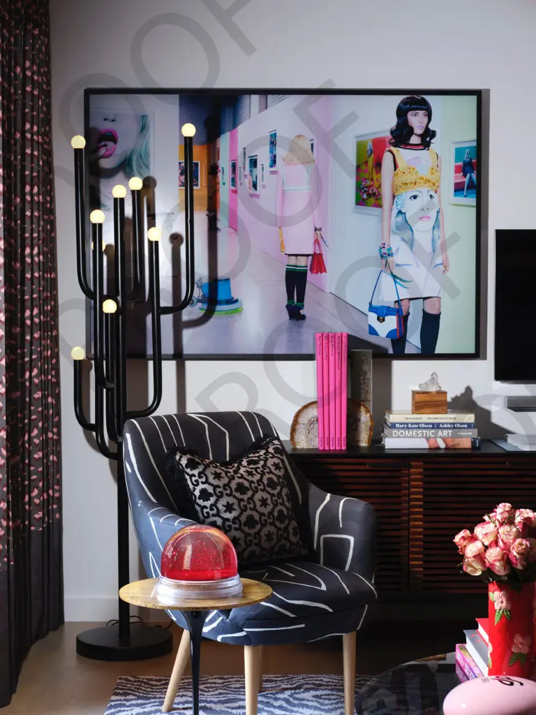  An area in the living room includes a 1970s floor lamp, a red snow globe acquired from Maison Margiela in Paris. The photograph, Prada Special, is from a Vogue Italia editorial by artist Miles Aldridge and acquired through the artist in London. (Photo by Lisa Petrole)