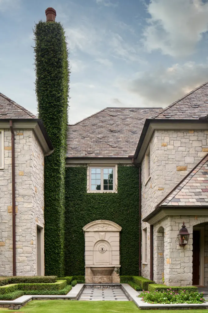 Ivy-clad stone walls on both sides of the entry at 120 Carnarvon are accented with antique French fountains. (Photo by Nathan Schroder for Douglas Elliman)