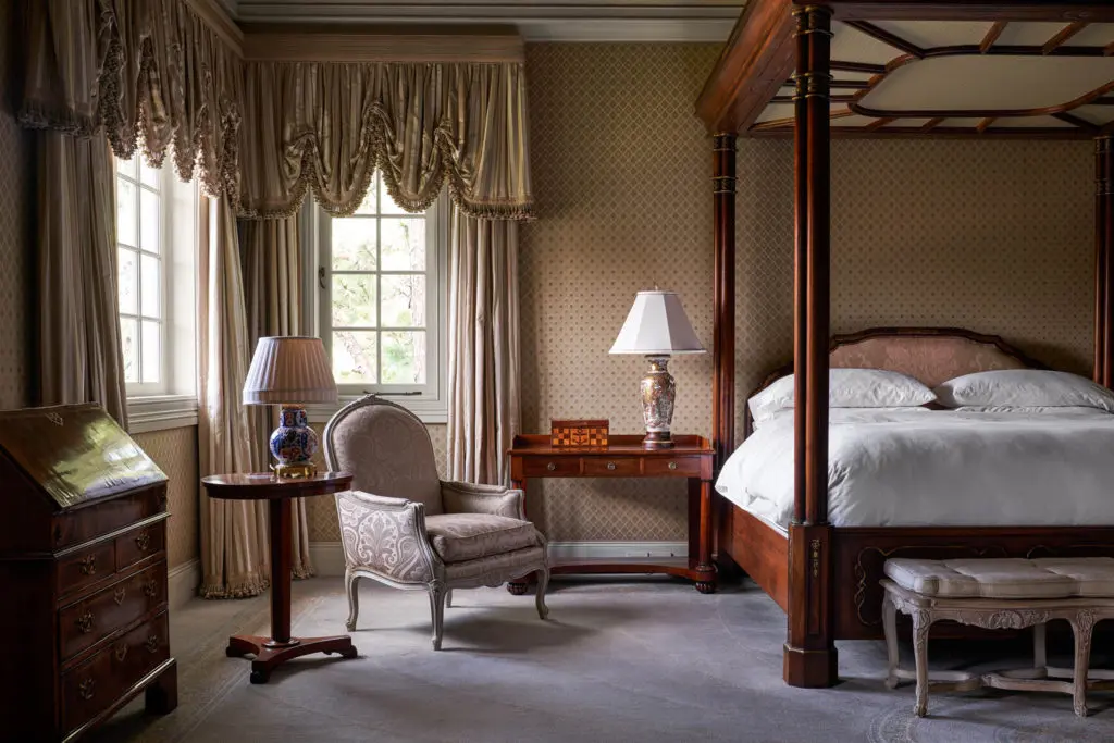 This bedroom, beautifully dressed in antiques and silks, could be straight from Highclere Castle. (Photo by Nathan Schroder/Douglas Elliman)