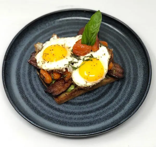 Avocado Texas Toast with Tomato-Basil Confit, Slab Bacon, Sunny Eggs
