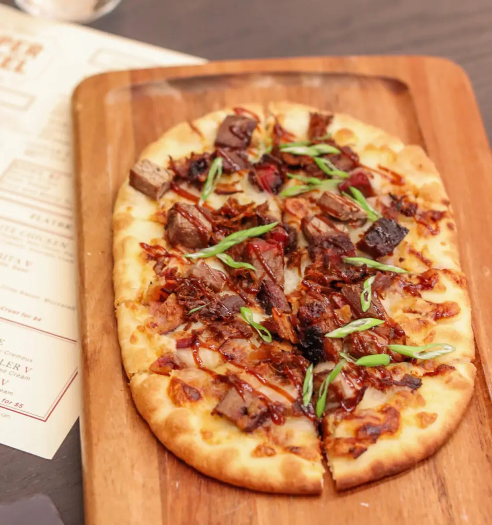 The Pit Master Flatbread comes with brisket, pulled boar, bacon, and ancho BBQ.