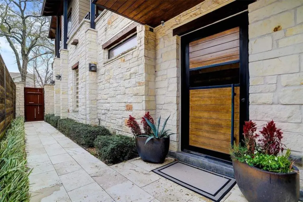 The house construction is a combination of Austin White chiseled stone with artisan board and iron details.