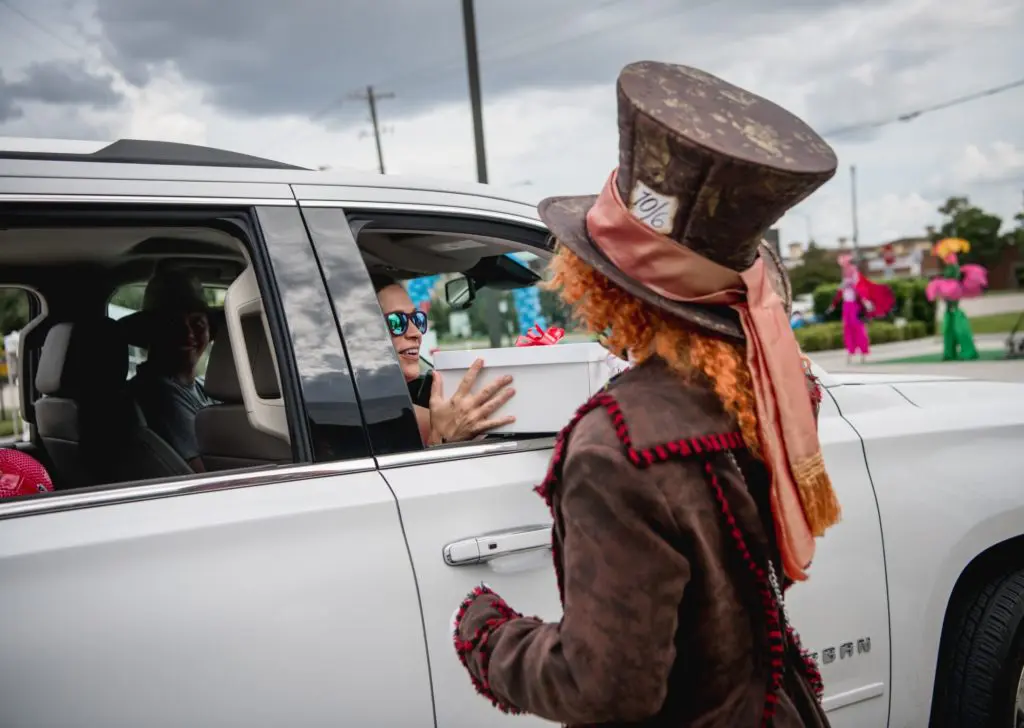 The Mad Hatter delivers craft kits to kiddos in the drive-through 'tea party.' (Photo by  Brandy Stoesz Photography)
