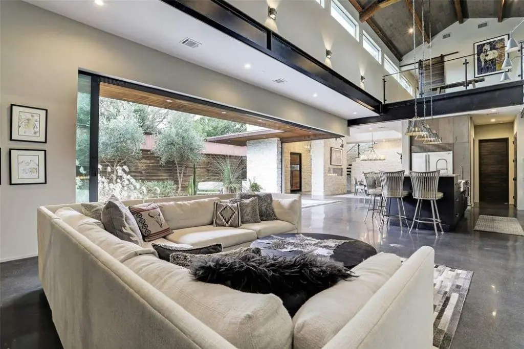 A view from the corner of the living room shows the exposed steel I-beam supports, which allow for an unobstructed opening. 